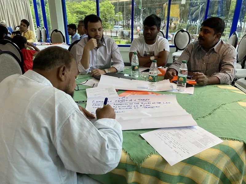 several men sitting a table reviewing documents