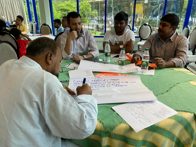 several men sitting a table reviewing documents