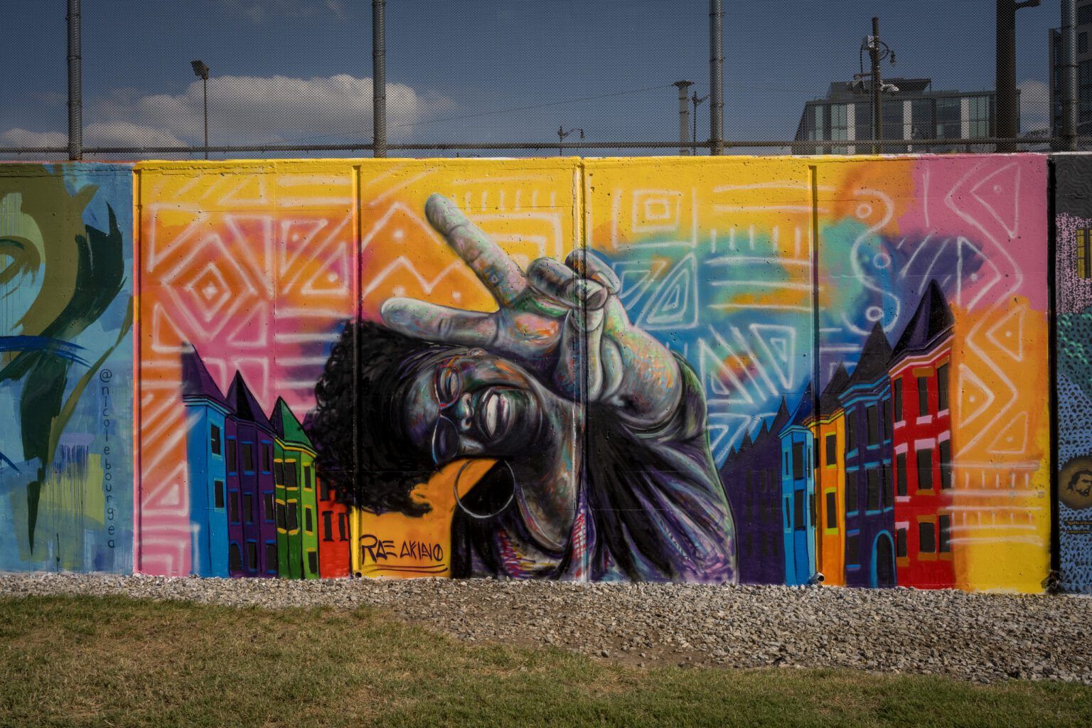 large outdoor mural of a black woman making a peace sign